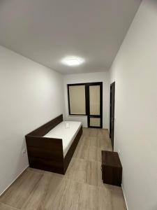 1 dormitorio con 1 cama y suelo de madera en St George Apartcomplex en Shkorpilovtsi