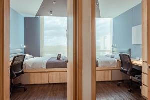 a bedroom with a bed and a desk and two chairs at UMA Suites Chia in Chía +86 photos
