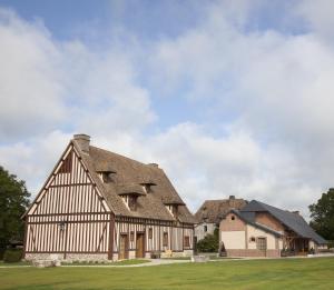 un antiguo granero con techo de gambrel en Manoir de Surville en Surville