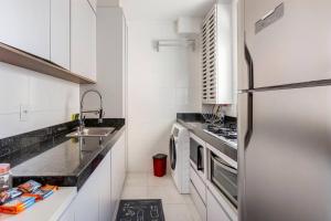 una cocina con frigorífico y fregadero en Lugar de descanso, en Rio das Ostras
