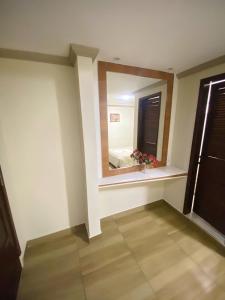 a room with a large mirror and a window at Pousada Dom Fernandes in Cabo Frio