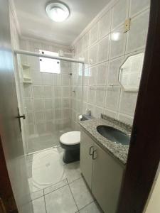 a bathroom with a toilet and a sink at Pousada Dom Fernandes in Cabo Frio