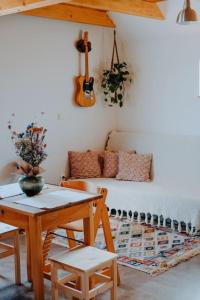 ein Wohnzimmer mit einem Tisch und einem Sofa mit einer Gitarre in der Unterkunft Domček in Nové Zámky