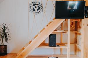 einen TV auf einem Stand in einem Zimmer mit einer Treppe in der Unterkunft Domček in Nové Zámky