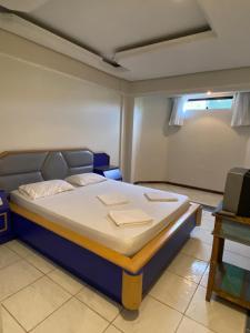 ein Schlafzimmer mit einem großen Bett in einem Zimmer in der Unterkunft Villa do Lago in Poços de Caldas
