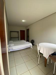 Schlafzimmer mit einem Bett, einem Tisch und Stühlen in der Unterkunft Villa do Lago in Poços de Caldas