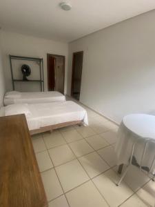 Zimmer mit einem Bett und einem Tisch in der Unterkunft Villa do Lago in Poços de Caldas