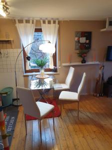a living room with a glass table and white chairs at Traumpfade in Boppard