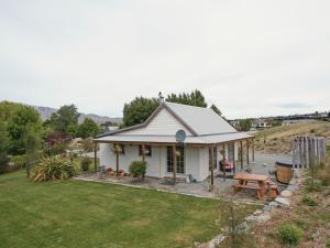 a white cottage with a picnic table in a yard at Lexi's Lodge in Lake Tekapo