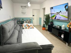 a living room with a couch and a flat screen tv at Apartamento Copa Resort HIR 19 in Rio de Janeiro