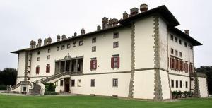 a large white building with red windows on a field at La Torretta, Decameron View, sweet apartment in Certaldo