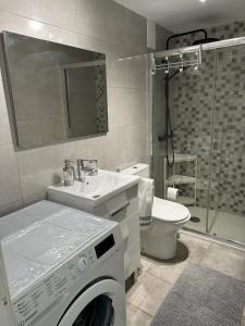 y baño con lavadora y lavamanos. en APARTAMENTOS SURYCAN, en San Bartolomé