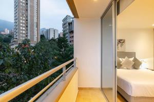 een balkon met een bed en uitzicht op de stad bij Spacious 2 bedroom apartment in the heart of Provenza in Medellín