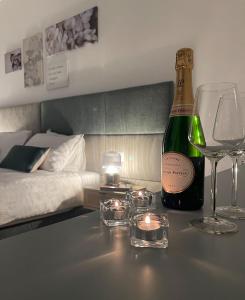 a bottle of wine and glasses on a table in a bedroom at B&B Domus Teano Luxury Rooms in Rome
