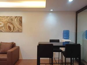 a room with a table and chairs and a couch at Syv's 2Br & 1T/Bath Condo Oasis Behind SM Mall 411 in Davao City