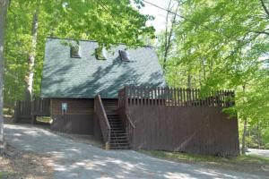 a wooden house with a fence and a gate at A-Frame Cabin #5 with Hot Tub on Patoka Lake in Southern Indiana in Paoli