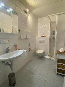 a white bathroom with a sink and a toilet at Boutique-Hotel Antica Posta in Ascona