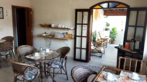 a restaurant with tables and chairs in a room at Pousada Primavera in Caraguatatuba