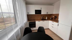 eine Küche mit weißen Schränken und einem großen Fenster in der Unterkunft 2 room Apartment with terrace, new building, 25 in Bratislava