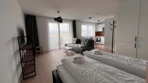 ein Wohnzimmer mit 2 Betten und einem Sofa in der Unterkunft 2 room Apartment with terrace, new building, 25 in Bratislava
