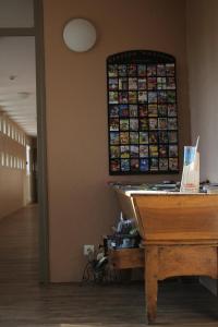 an office with a desk and a piano in a hallway at Logis Drom'sud Hotel in Donzère