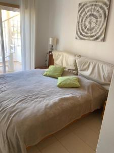 a large bed with two green pillows on it at Royal Cabanas Gold penthouseT2 in Conceição