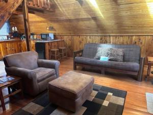 a living room with a couch and a chair at A-Frame Cabin #6 with Hot Tub on Patoka Lake in Southern Indiana in Seymour +1 photo