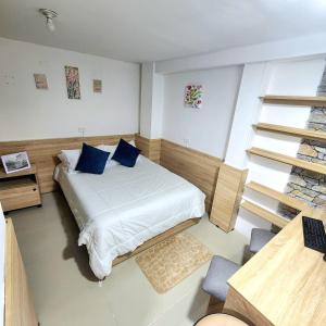 1 dormitorio con 1 cama con almohadas azules en Apartamentos todos con aire acondicionado, en Ibagué