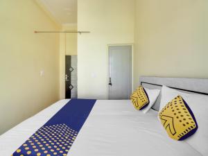 a bedroom with a bed with yellow and blue polka dot pillows at OYO Hotel Mount View in Haldwāni