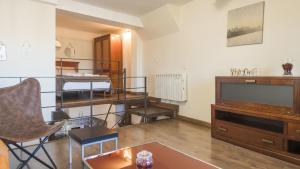 a living room with a tv and a room with bunk beds at Apartamentos Zocosol by Toledo AP in Toledo