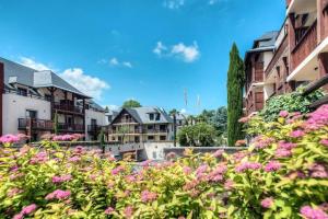 a bunch of pink flowers in front of buildings at Appartement de la Marmotte Cendrée, dans résidence de tourisme 3 étoiles in Lourdes
