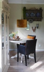 una sala da pranzo con tavolo e sedie bianchi di Hof van Benten a Ermelo