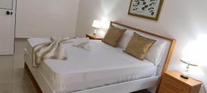 a white bed in a room with two lamps at Zeyden Place Apt in Praia