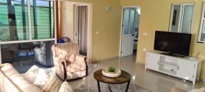 - un salon avec un canapé et une télévision dans l'établissement Zeyden Place Apt, à Praia
