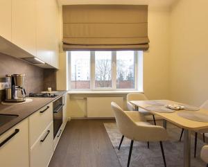 Una pequeña cocina con una mesa y una ventana. en Butas Šiaulių mieste, en Šiauliai