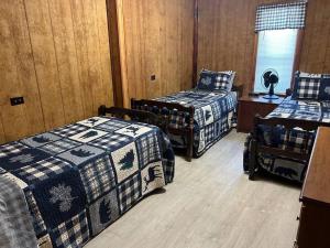 Una habitación con 2 camas y una mesa con una falda. en Adjoining Cabin #7A at Patoka 4 Seasons Resort en Scottsburg