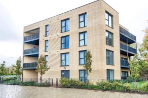 a large brick building with a fence in front of it at Beautifully furnished 3-bed apartment near Wembley Stadium in Wealdstone