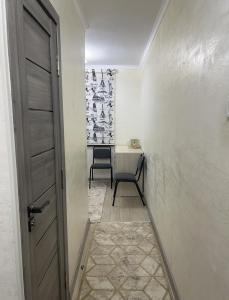 a hallway with a door and a chair in a room at Апартаменты 2-х и 1 комнатные in Taraz