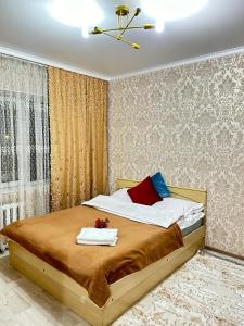1 dormitorio con 1 cama con 2 toallas en Апартаменты 2-х и 1 комнатные, en Taraz