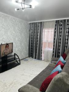 a living room with a couch and a flat screen tv at Апартаменты 2-х и 1 комнатные in Taraz