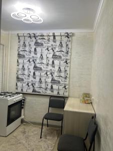cocina con fogones, mesa y silla en Апартаменты 2-х и 1 комнатные, en Taraz
