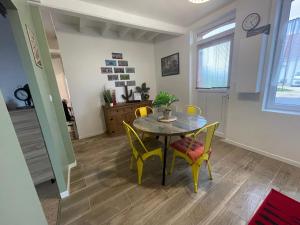 a dining room with a table and yellow chairs at la Casa d'Olianna - Jolie Maison / Jeux / Grand jardin in Villeny