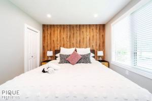 1 dormitorio con 1 cama blanca grande con almohadas en Forest Heights Upstairs en Edmonton