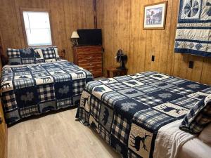 a bedroom with two beds and a television in it at Adjoining Cabin #7B on Patoka Lake in Southern Indiana in Mitchell
