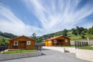 a couple of small wooden buildings in a field at BUNGALOWS MARTINA in Coó