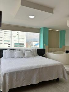 um quarto com uma cama grande e uma banheira em Hotel Arthur Brich em Cúcuta