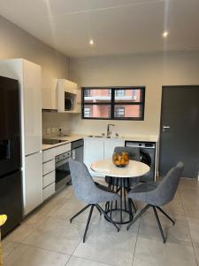 a kitchen with a table and chairs in a kitchen at The Fitz Apartment in Johannesburg