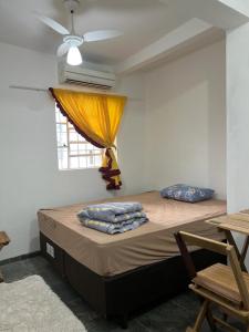 a bedroom with a bed with a ceiling fan and a window at Artista Helo Ceres0025 in Cuiabá