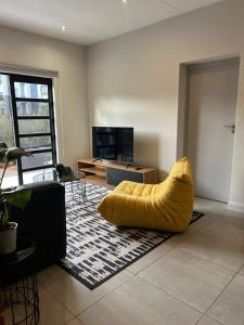 a yellow bean bag chair in a living room at The Fitz Apartment in Johannesburg