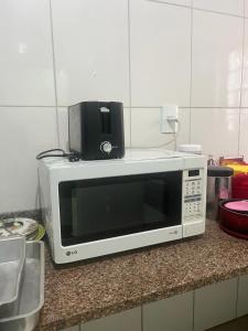 a microwave sitting on top of a counter at Artista Helo Ceres0025 in Cuiabá